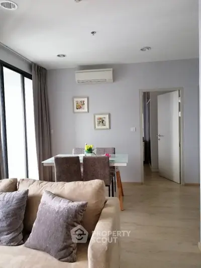 Modern living room with dining area, featuring cozy sofa and elegant decor.