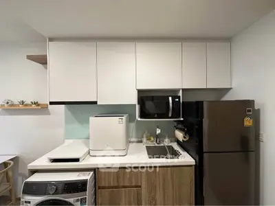 Modern kitchen with sleek cabinetry, appliances, and stylish decor in a contemporary apartment.