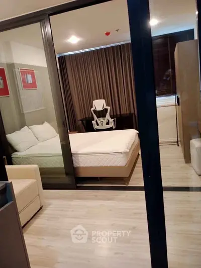 Modern bedroom with glass sliding doors and stylish decor in a contemporary apartment.