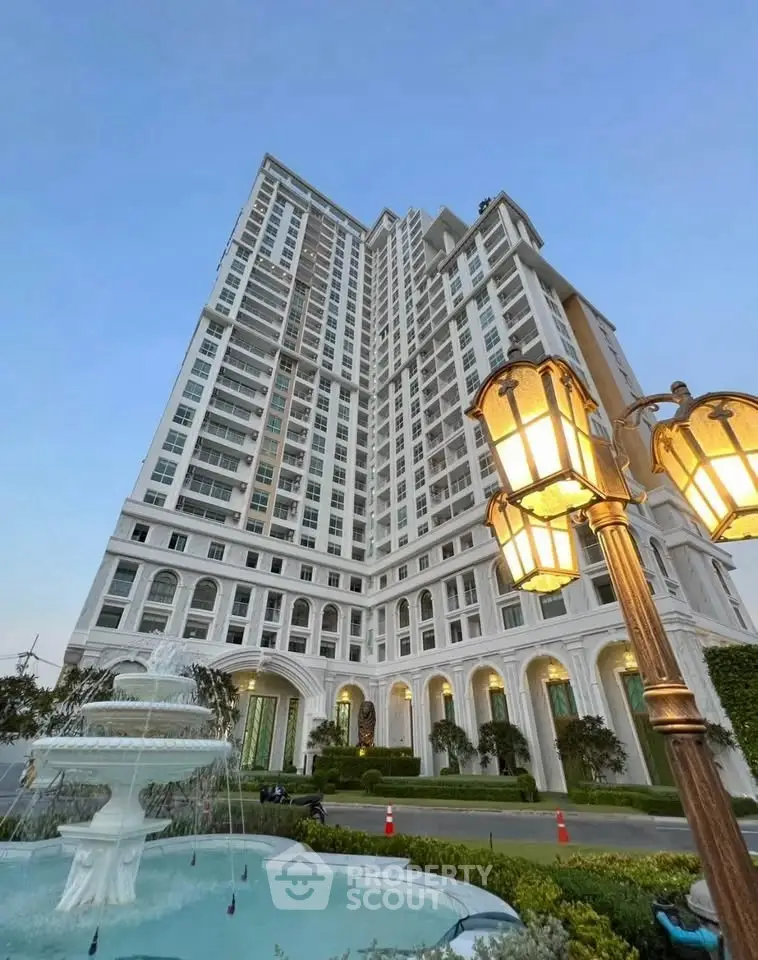 Luxurious high-rise building with elegant architecture and fountain in foreground, perfect for upscale living.