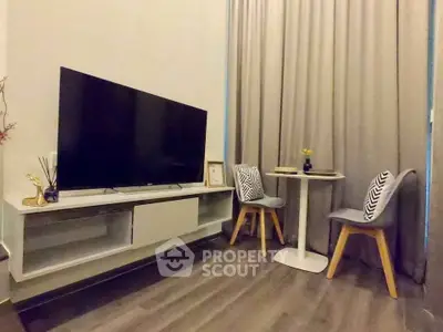 Modern living room with sleek TV setup and cozy dining area, perfect for urban living.
