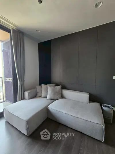 Modern living room with sleek design and large windows offering natural light.
