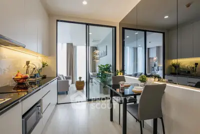 Modern open-layout kitchen with sleek design and dining area, leading to a cozy living room with natural light.
