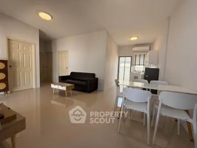 Spacious modern living room with dining area and sleek furniture in a bright apartment.