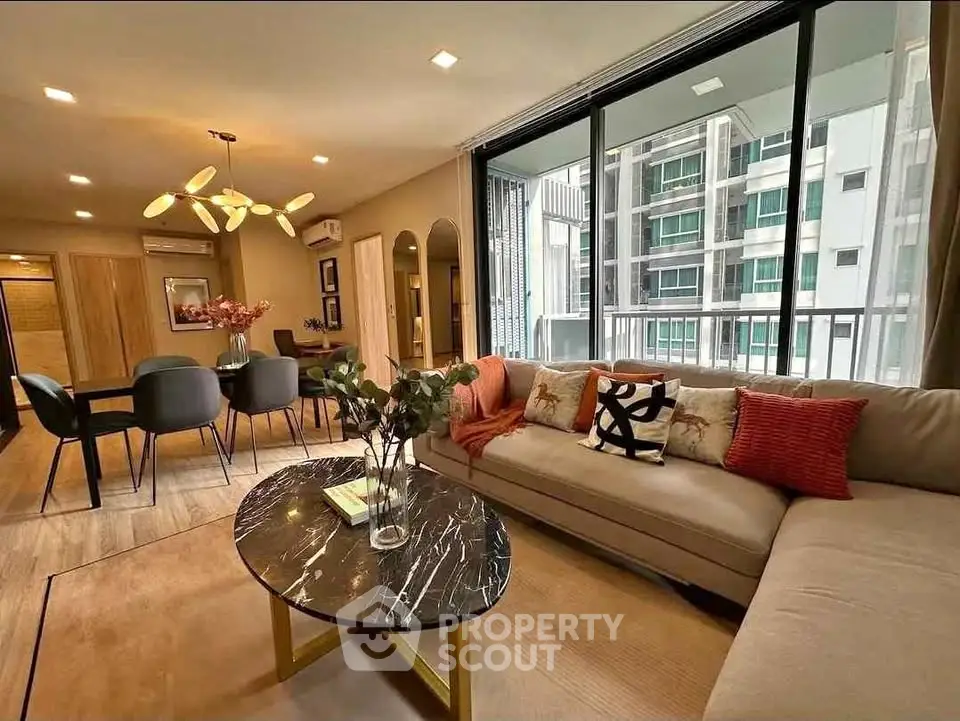 Modern living room with stylish decor and large windows in a high-rise apartment.