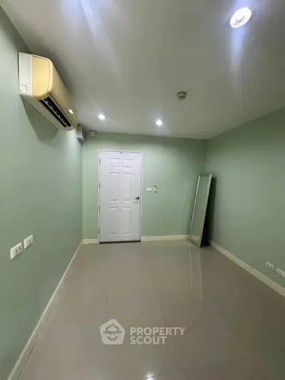 Spacious empty room with air conditioning and sleek tile flooring