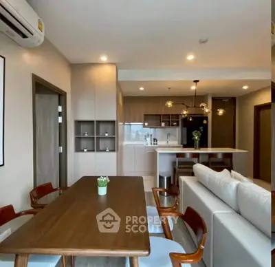 Modern open-layout living room and kitchen with stylish furniture and elegant lighting.