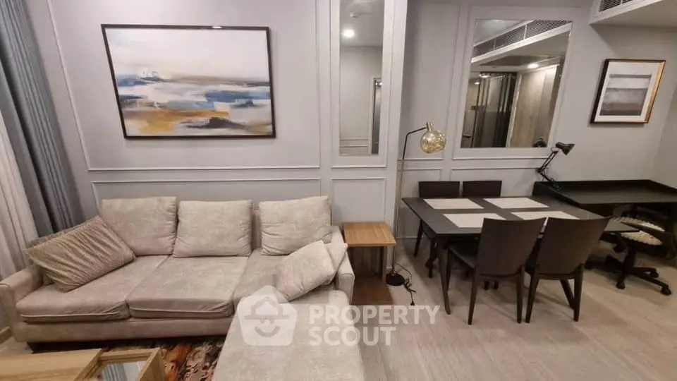 Modern living room with stylish decor and dining area, featuring a cozy sofa and elegant lighting.