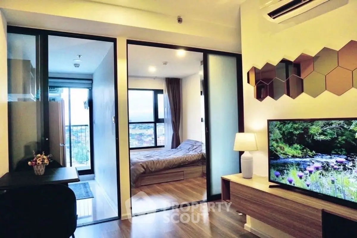Modern apartment with open living room and bedroom, featuring stylish decor and natural light.