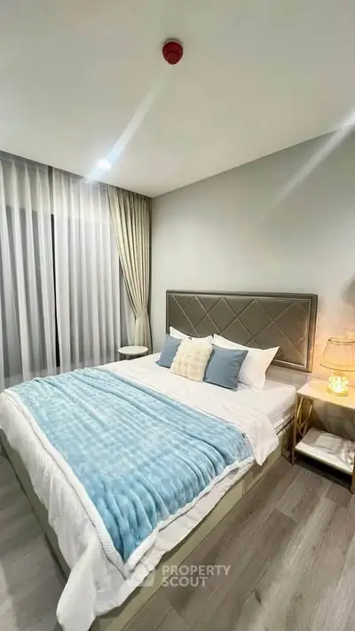 Elegant bedroom with plush bedding and modern decor in a cozy apartment.