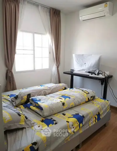 Cozy bedroom with air conditioning and natural light, featuring a playful themed bedding set.