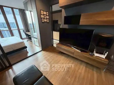 Modern apartment interior with sleek living room and cozy bedroom, featuring wooden flooring and stylish decor.
