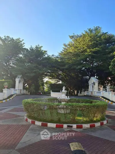 Elegant gated entrance with lush greenery and classic architecture