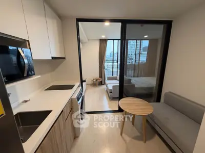 Modern apartment with open kitchen and cozy living area featuring city view.