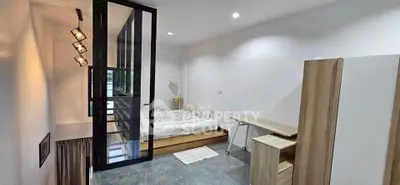 Modern bedroom with glass partition and minimalist decor in a stylish apartment.