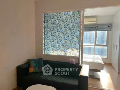 Cozy living room with modern decor and adjacent bedroom in bright apartment.