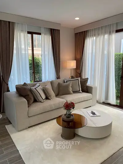 Elegant living room with modern decor and natural light, featuring a cozy sofa and stylish coffee table.