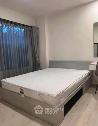 Modern bedroom with stylish bed and natural light from large window.