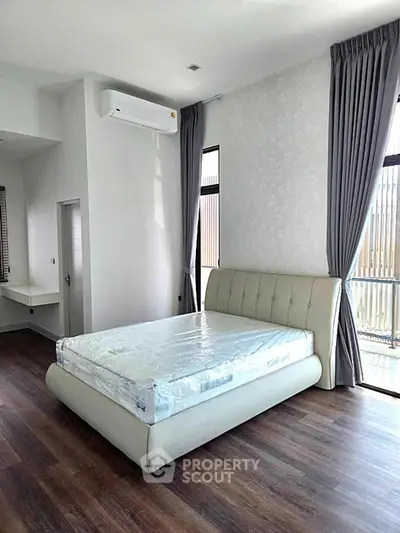 Spacious bedroom with modern design and large windows for natural light.