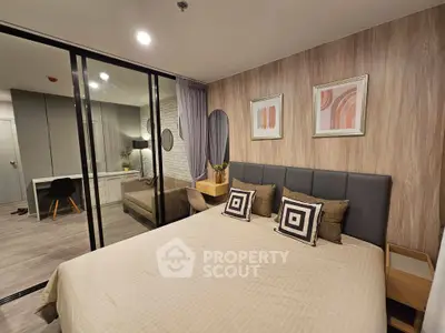 Modern bedroom with stylish decor and glass partition leading to a cozy study area.