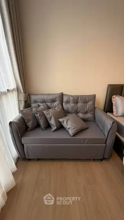 Cozy living room corner with stylish gray sofa and plush cushions, perfect for relaxation.