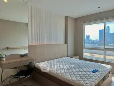 Modern bedroom with large window offering city view, featuring a stylish desk and comfortable bed.