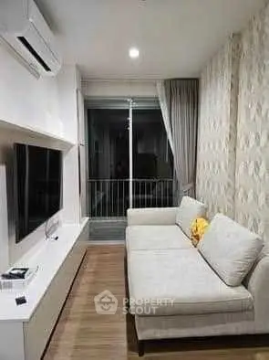 Modern living room with sleek design and cozy sofa, featuring a large TV and balcony access.