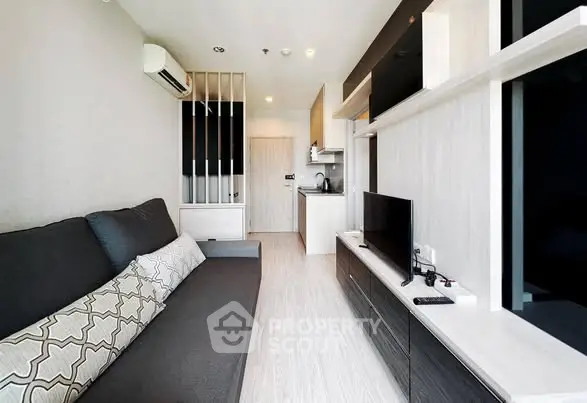 Modern living room with sleek design and open kitchen layout in a stylish apartment.