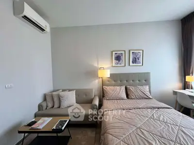 Modern bedroom with cozy bed, stylish sofa, and elegant decor in a contemporary apartment.