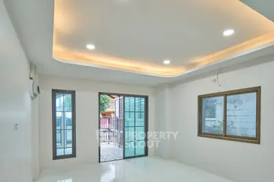 Modern living room with recessed lighting and balcony view