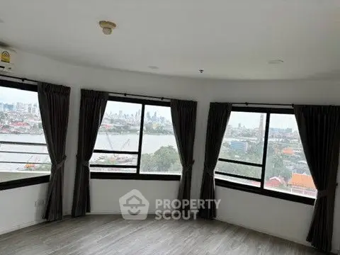 Spacious corner unit with panoramic city and river views, featuring large windows and elegant flooring.
