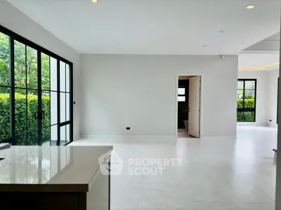 Spacious modern living room with large windows and garden view, perfect for natural light lovers.