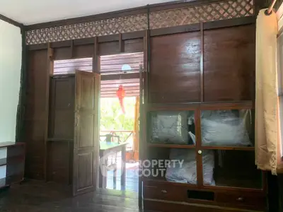 Charming wooden interior with rustic decor and outdoor view, perfect for cozy living.