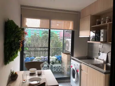 Modern kitchen with balcony view, featuring washing machine and dining area, perfect for urban living.