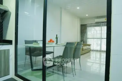 Modern dining area with glass partition and cozy living room