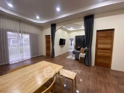 Spacious modern living room with wooden flooring and elegant curtains