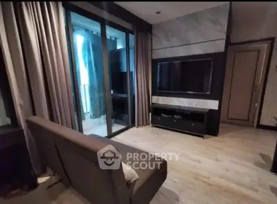 Modern living room with sleek TV setup and balcony access