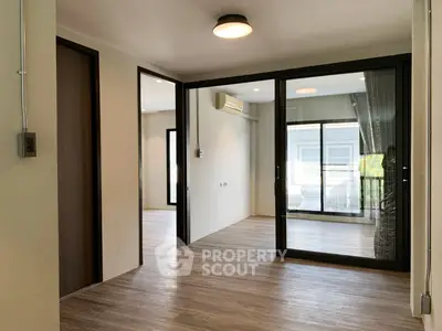 Spacious modern living area with sliding glass doors and wood flooring