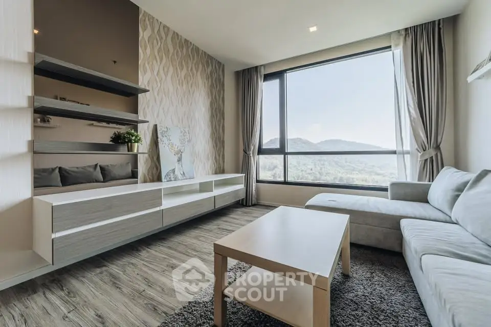 Modern living room with large window offering stunning mountain views, stylish furniture, and elegant decor.