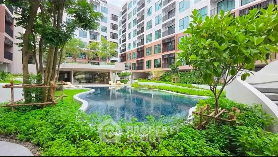 Modern apartment complex with lush garden and inviting swimming pool
