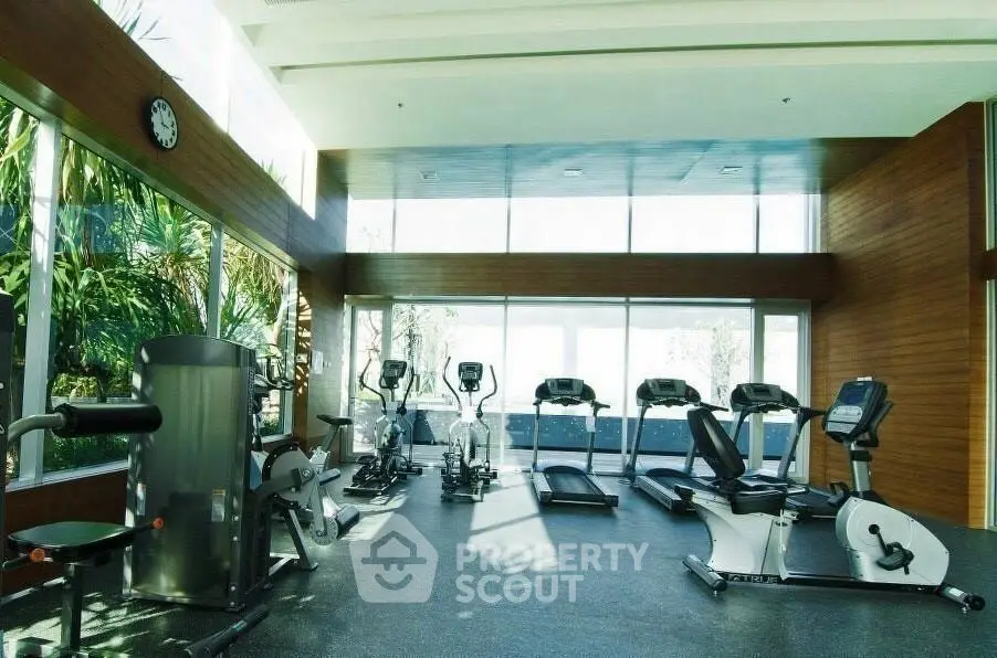 Modern gym with state-of-the-art equipment and large windows offering natural light.