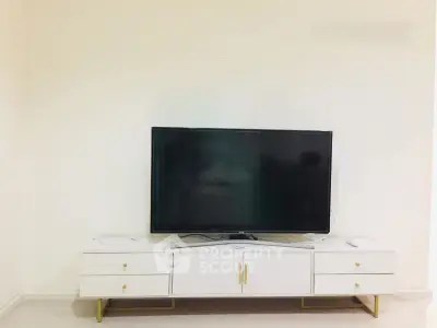 Modern living room with sleek TV stand and flat-screen television, perfect for entertainment.