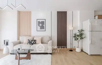 Modern living room with stylish decor and cozy ambiance, featuring a plush sofa and sleek glass coffee table.
