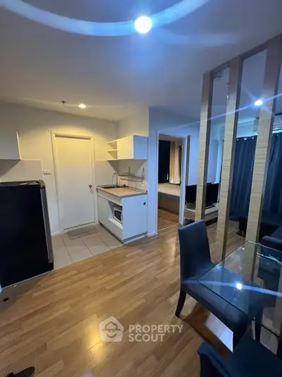 Modern open-plan kitchen and dining area with sleek design and wooden flooring.