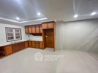 Spacious kitchen with wooden cabinets and modern lighting in a contemporary home.