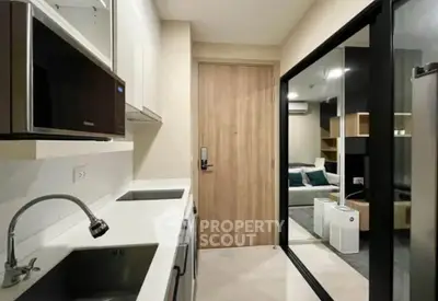 Modern kitchen with sleek design and open layout leading to cozy living room.