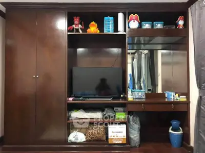 Spacious bedroom with built-in wooden wardrobe and entertainment center
