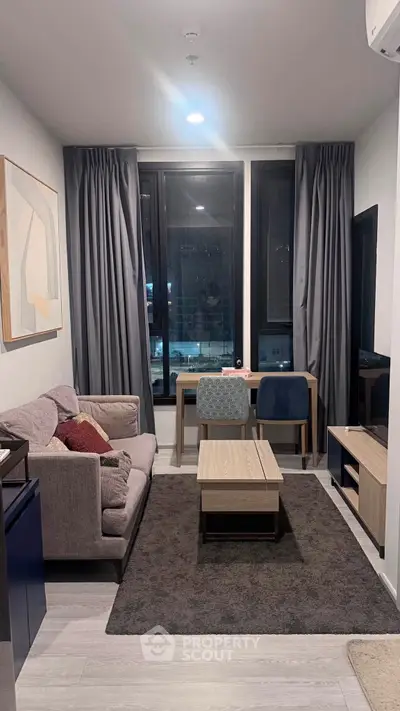 Modern living room with stylish furniture and large windows in a cozy apartment.