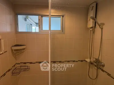 Modern bathroom with shower and water heater in a stylish real estate property.