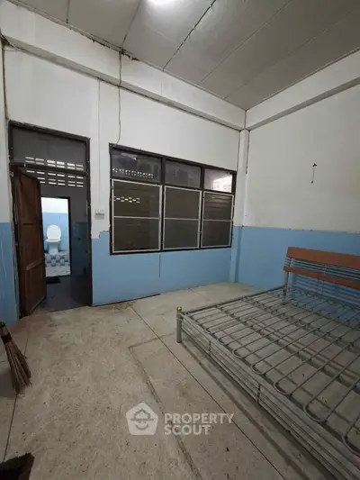 Spacious bedroom with metal bed frame and adjacent bathroom in minimalist design.